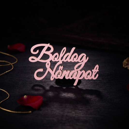 Rózsaszín, kalligrafikus betűtípusú Boldog Nőnapot fa felirat elölnézetből.