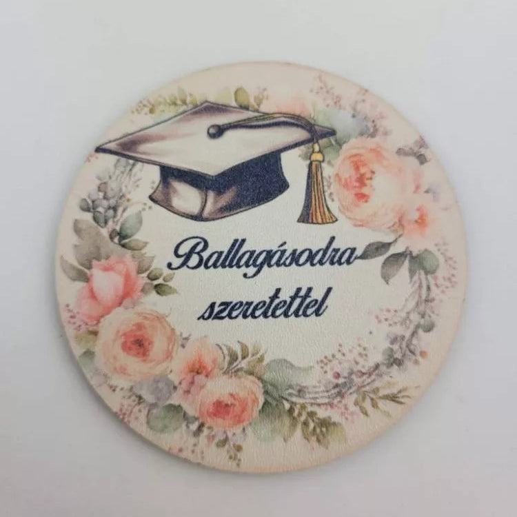 Ballagási betűző „Ballagásodra szeretettel" felirattal – 7,5 cm kerek dekorációs korong diplomasapkával és rózsaszín virágkoszorúval, ballagási csokor dísz