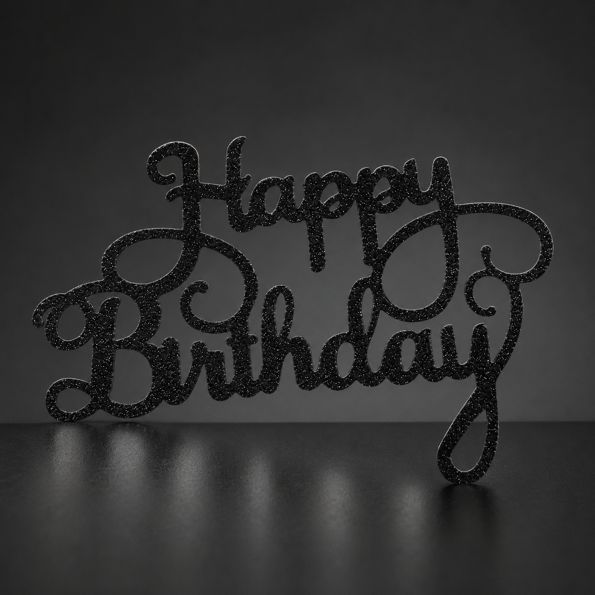 Fekete csillámos Happy Birthday torta betűző közelről, fa felületen