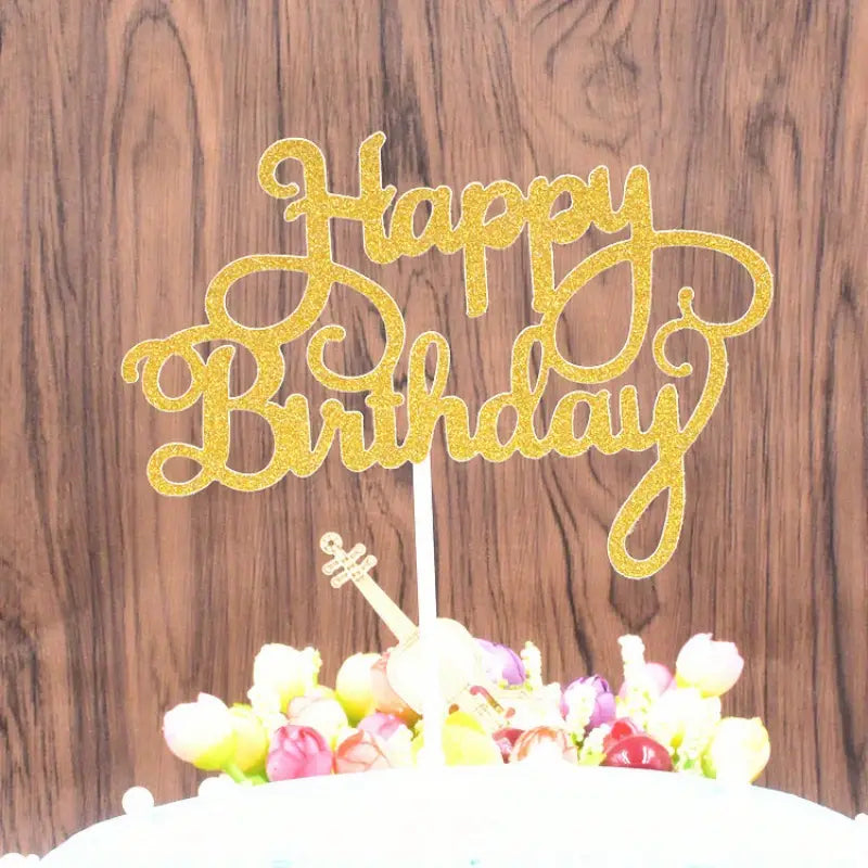 Arany csillámos Happy Birthday betűző szülinapi tortába szúrva, rózsákkal