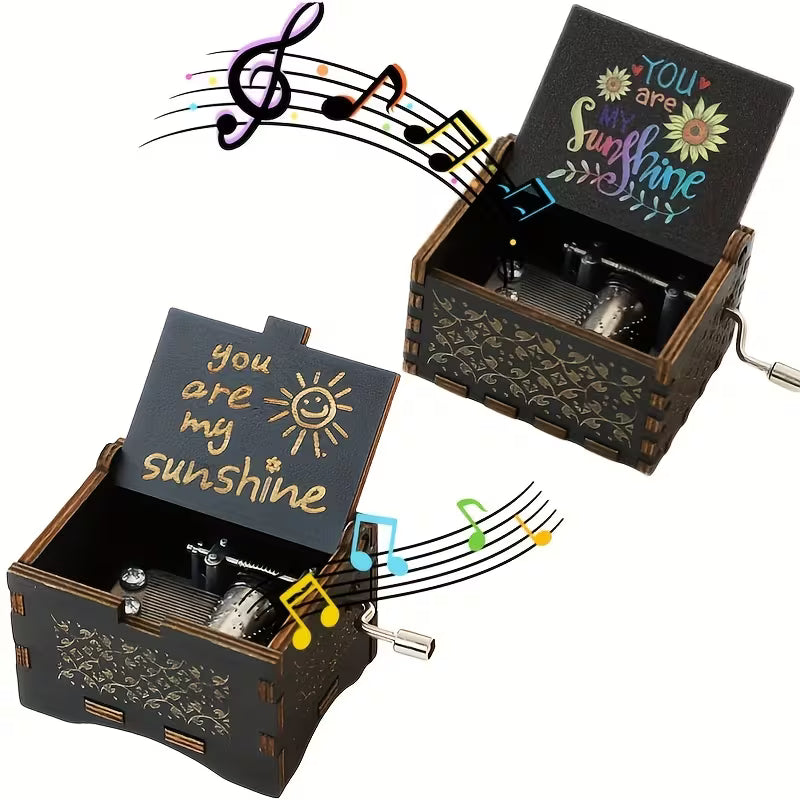 Két stílus egymás mellett — arany gravírozott és színes napraforgós You Are My Sunshine zenélő doboz