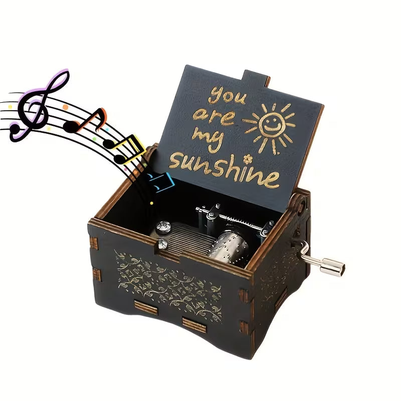 You Are My Sunshine zenélő doboz nyitva — arany lézergravírozott felirat napocskával, sötét fa, kézi hajtóműves szerkezet