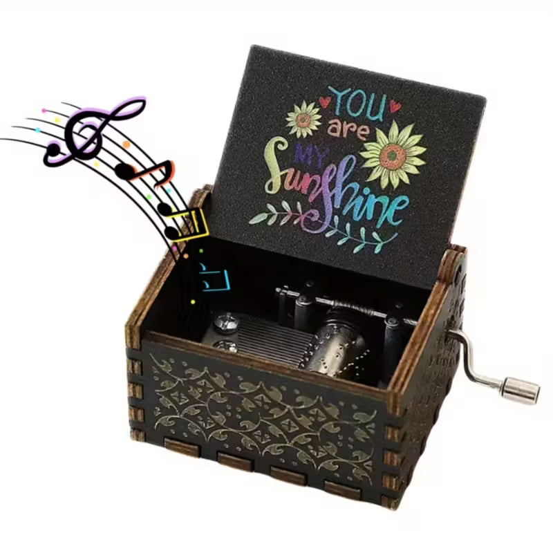 You Are My Sunshine zenélő doboz nyitva — színes napraforgós felirat a fedélen, sötét fa, kézi hajtóműves
